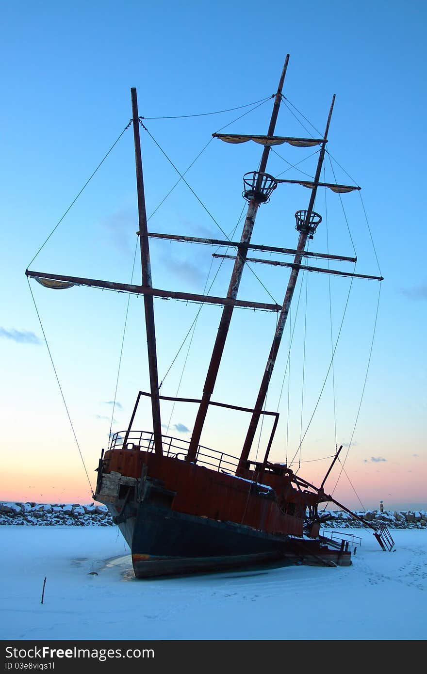 Old boat stranded on the land with sunset as background. Old boat stranded on the land with sunset as background