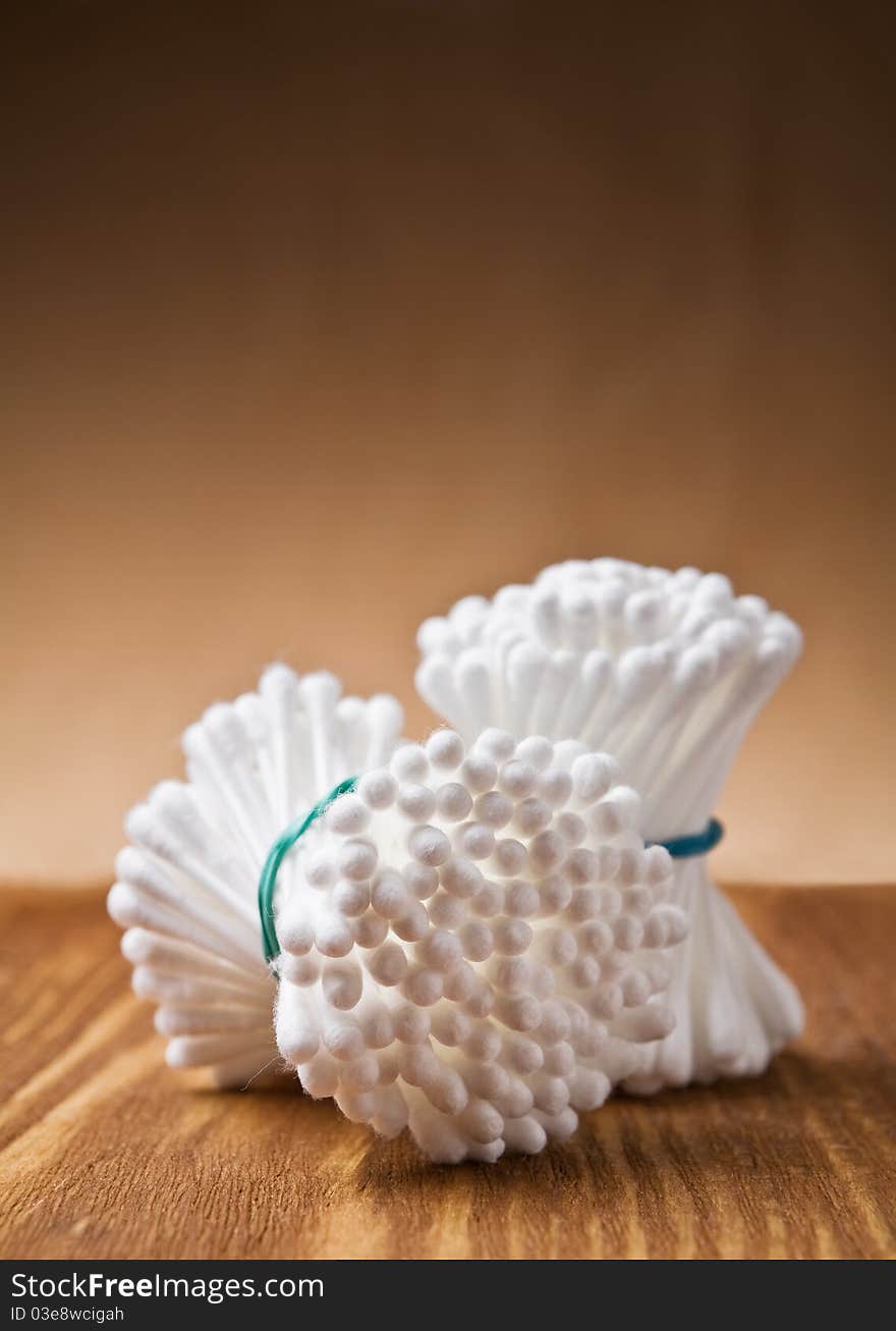 White cotton swabs on wooden background