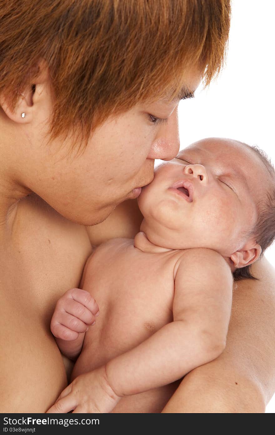 A oriental father holding on to his new baby showing his love and affection by giving her a kiss on his head. A oriental father holding on to his new baby showing his love and affection by giving her a kiss on his head.