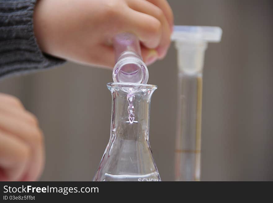 Child's hands are holding tubings to drop the liquid. Child's hands are holding tubings to drop the liquid