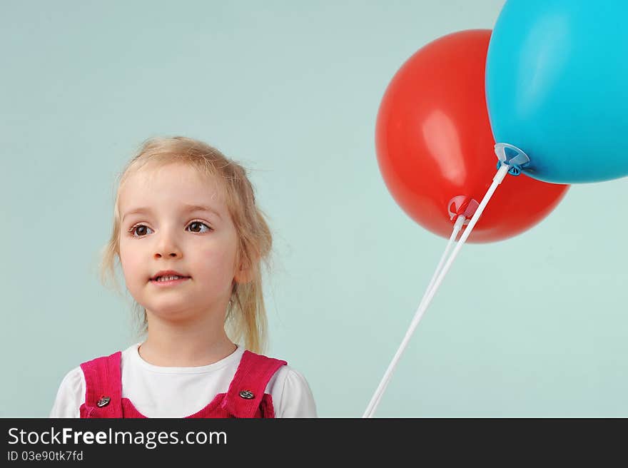 Lovely blond little girl with balloons. Portrait