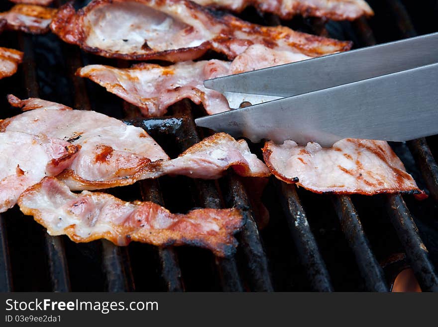 Rashers of bacon on a barbeque grill. Rashers of bacon on a barbeque grill