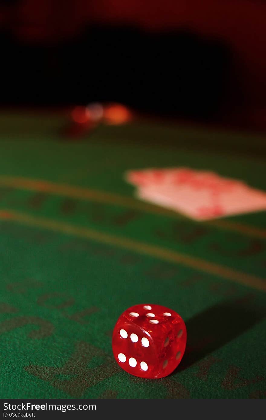 Green casino table with dice and a blurred hand of a royal flush in a poker game. Green casino table with dice and a blurred hand of a royal flush in a poker game