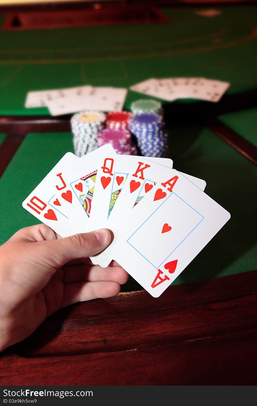 Green casino table with a hand of a royal flush in a poker game. Green casino table with a hand of a royal flush in a poker game