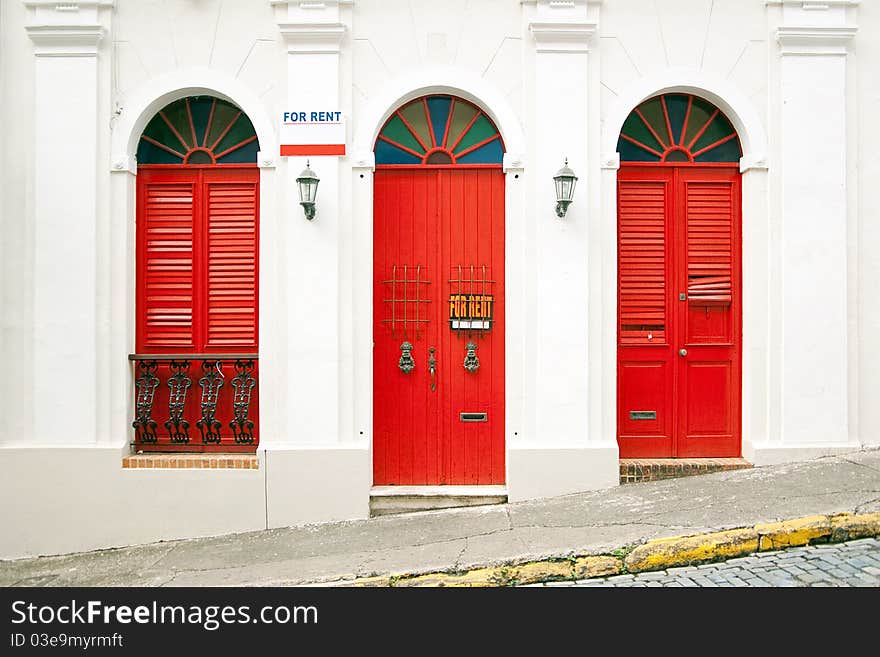 Entrance of a classic styled apartment with vintage tall red windows and marks FOR RENT. Entrance of a classic styled apartment with vintage tall red windows and marks FOR RENT