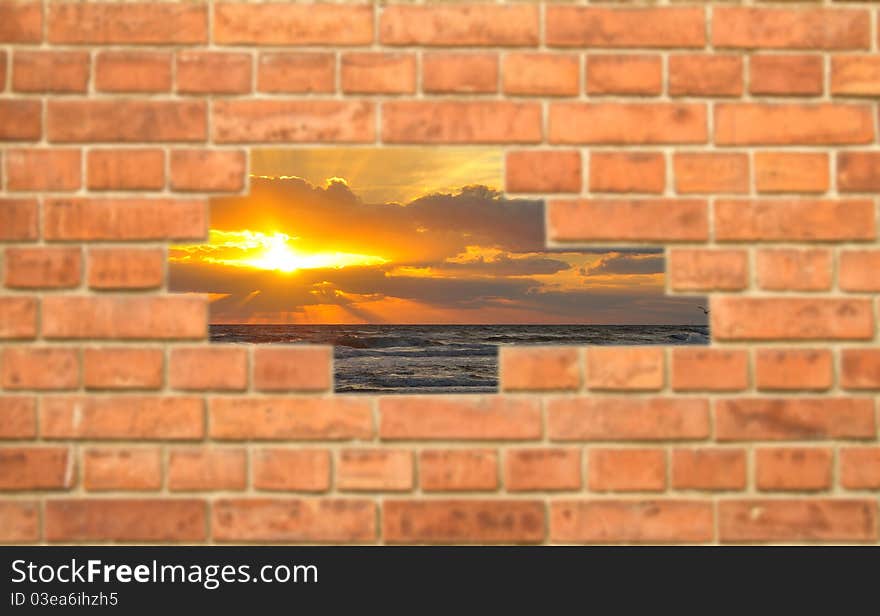 Hole in a brick wall showing a beach sunset (focus on sunset)