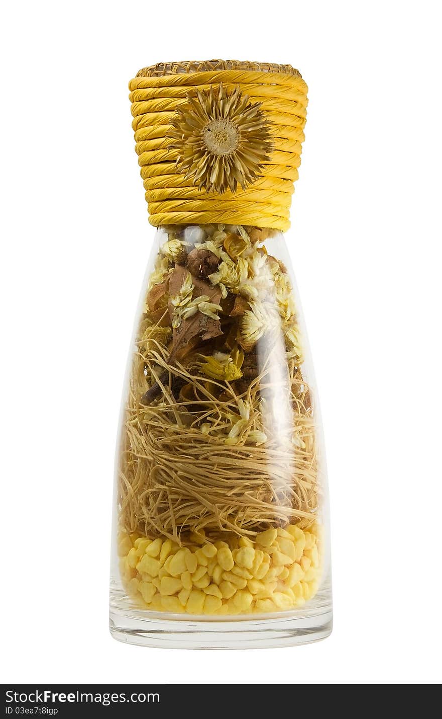 A glass bottle with dried herbs