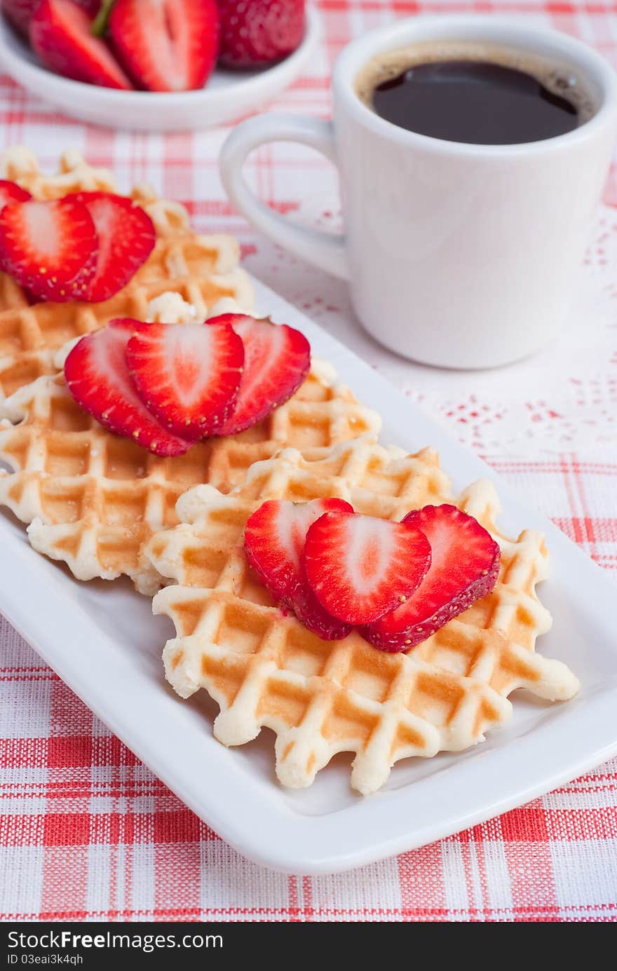 Waffles with strawberry and coffee.