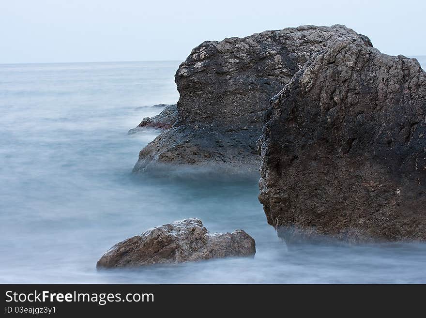 Rocks in the sea, covered with haze