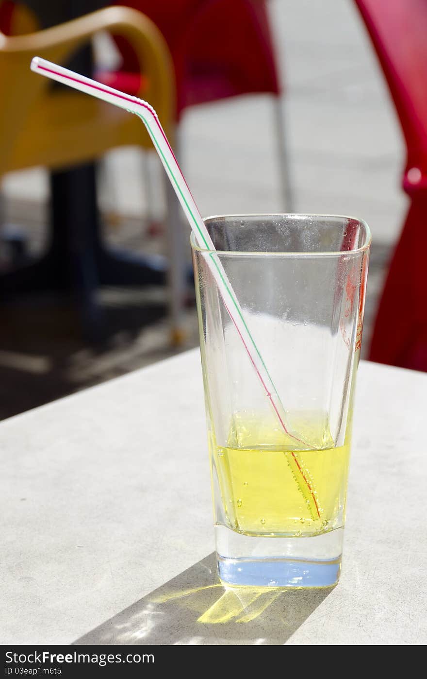 Glass of syrup on a beach table