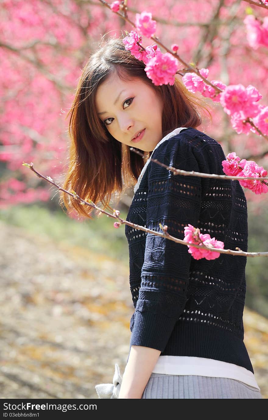 Young japanese woman outdoors by blossoms tree