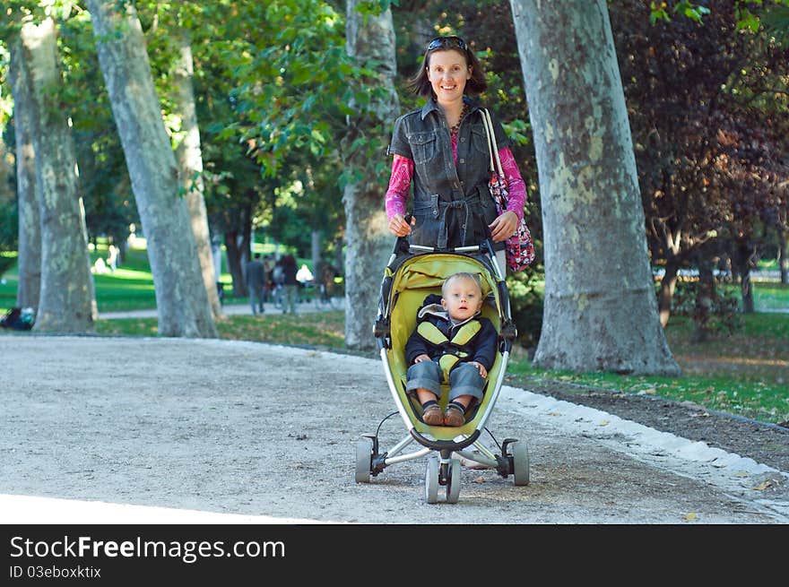 Happy mother with her son walking in the park in the sunny day