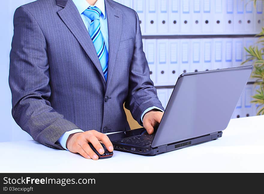 Close-up of male hand on mouse while working on laptop