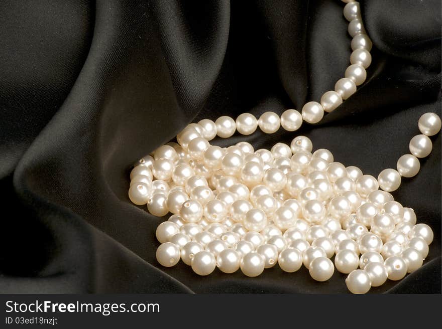 White pearls on a black satin fabric