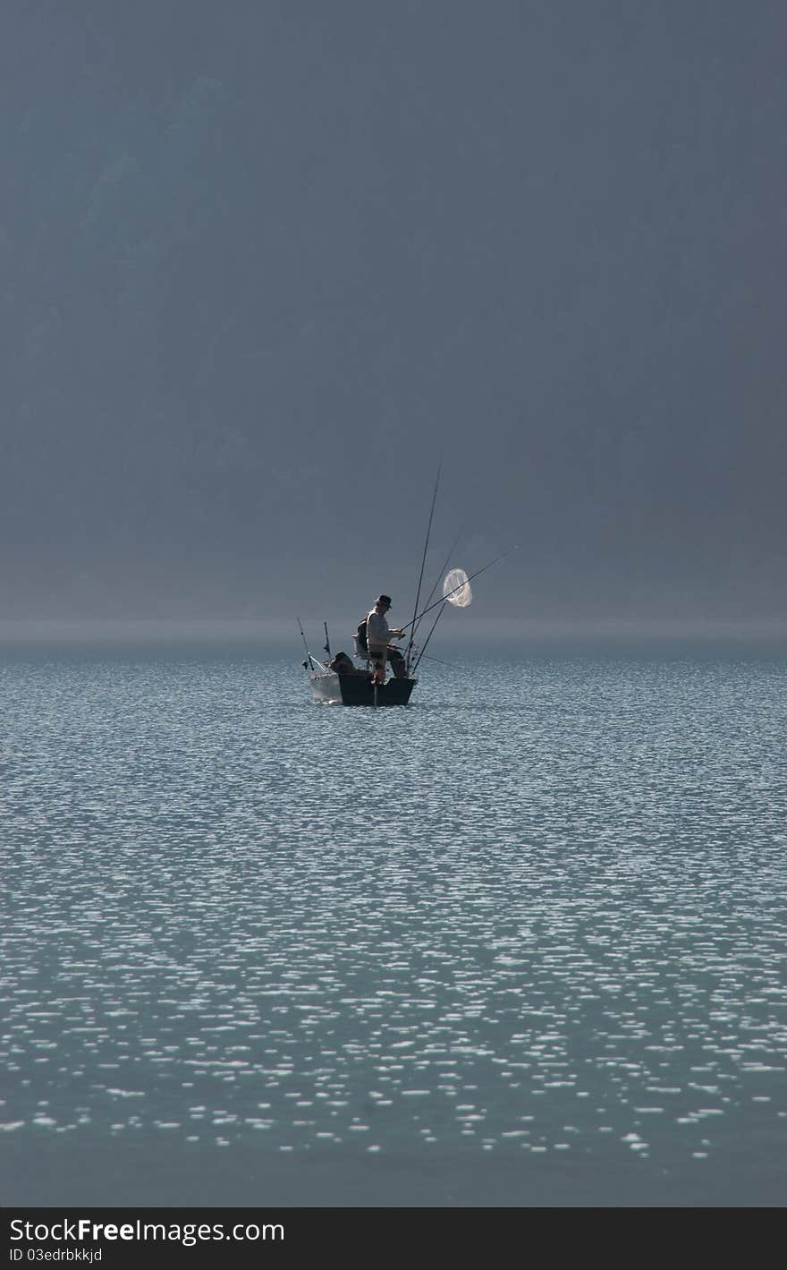 Fishermen on the lake on a misty morning. Fishermen on the lake on a misty morning