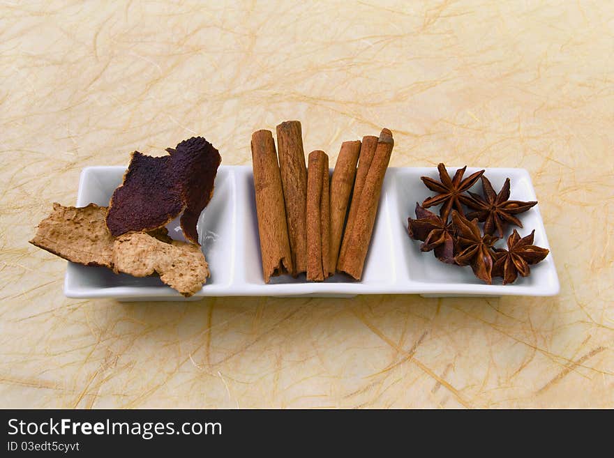 Herbs and spices in white dish.