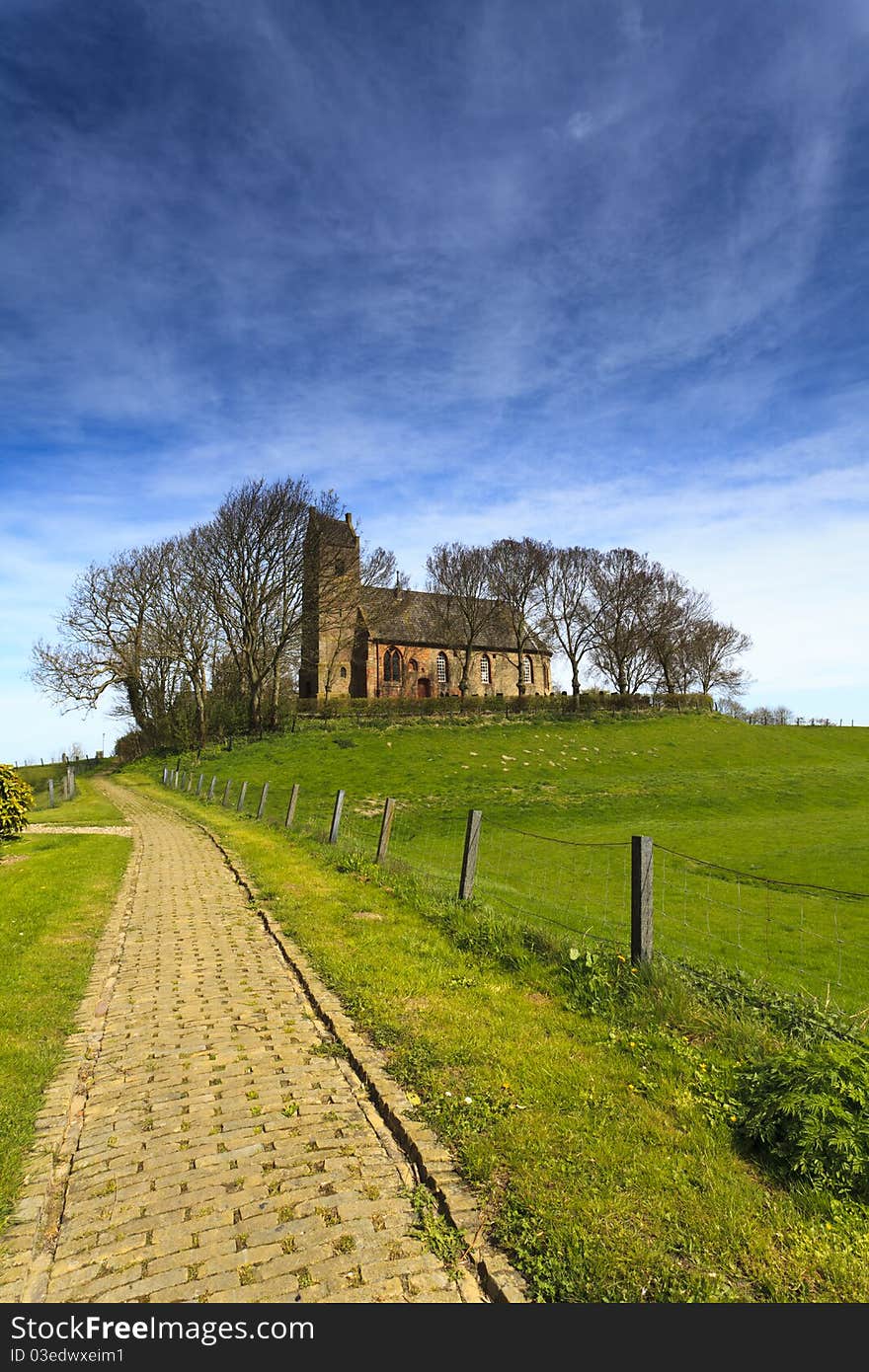 Path to an old church on a high hill surrounded with trees