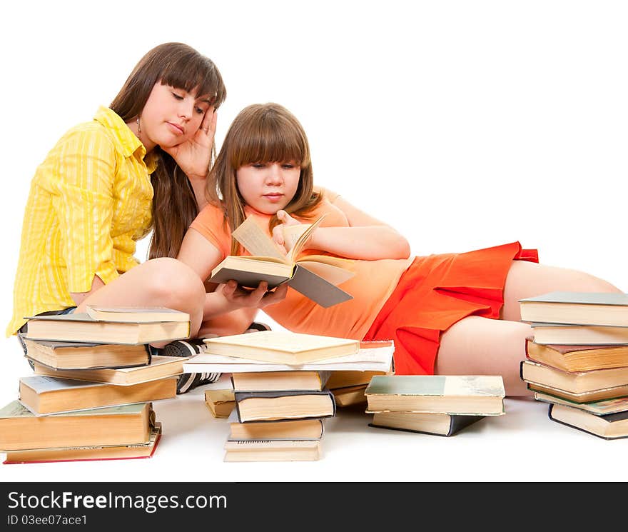 Two bored schoolgirls read many books isolated on white. Two bored schoolgirls read many books isolated on white