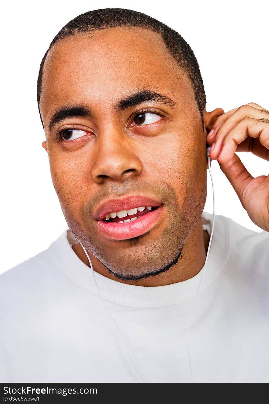 Man listening to music on a MP3 player isolated over white. Man listening to music on a MP3 player isolated over white