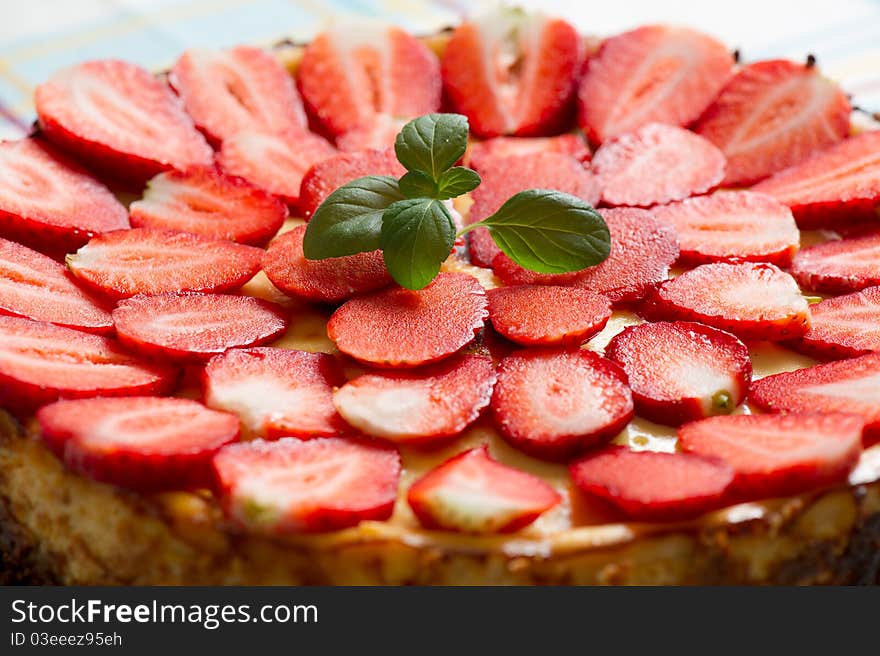 Top of a delicious strawberry vanilla cheesecake with mint. Top of a delicious strawberry vanilla cheesecake with mint.