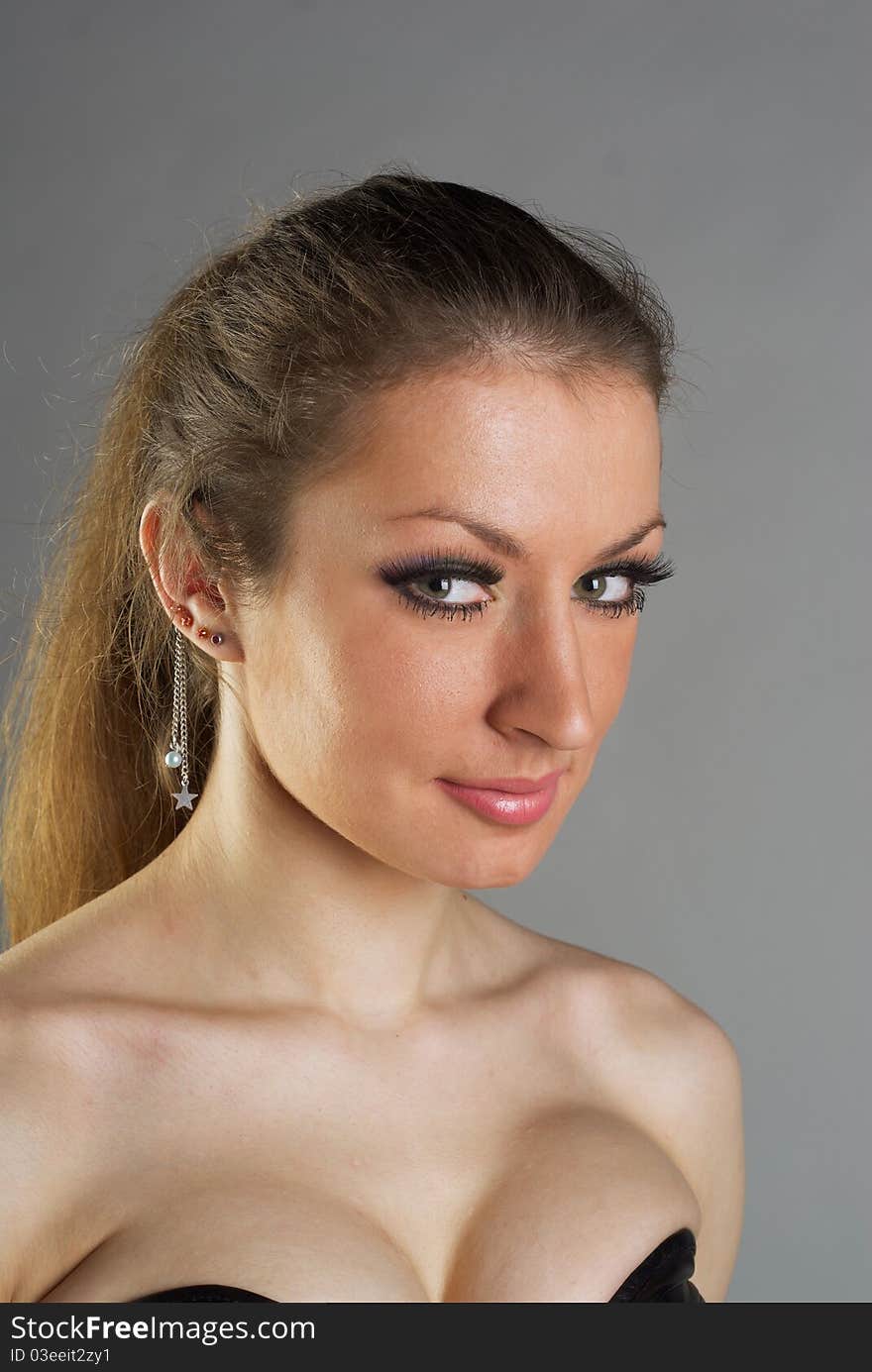 Portrait of the beautiful girl with long hair on grey background