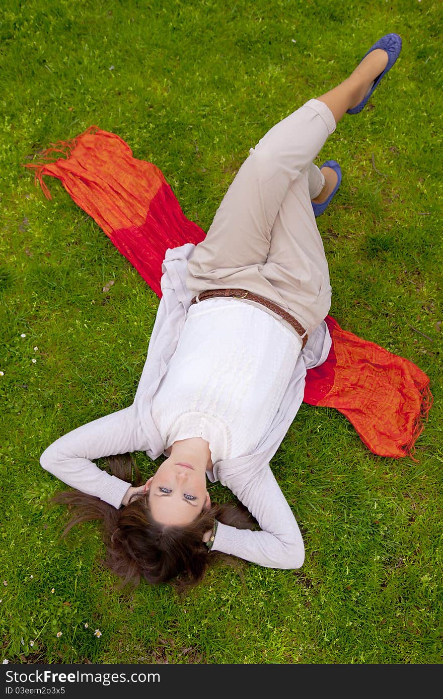 Young attractive woman thougthfully lying in the grass. Young attractive woman thougthfully lying in the grass.