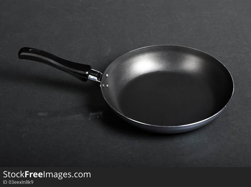 Frying pan on black background