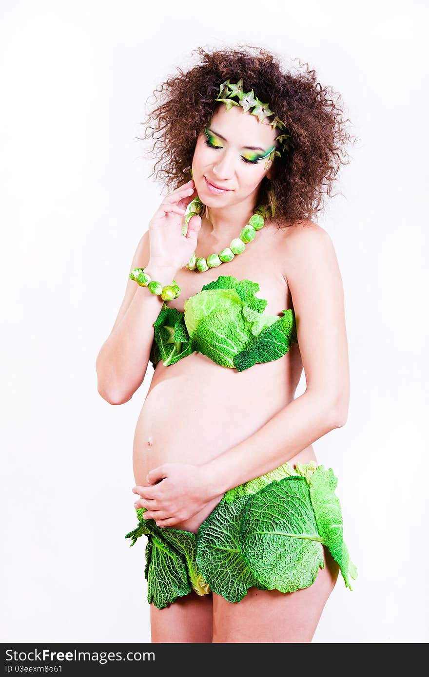 Beautiful pregnant young woman dressed in cabbage