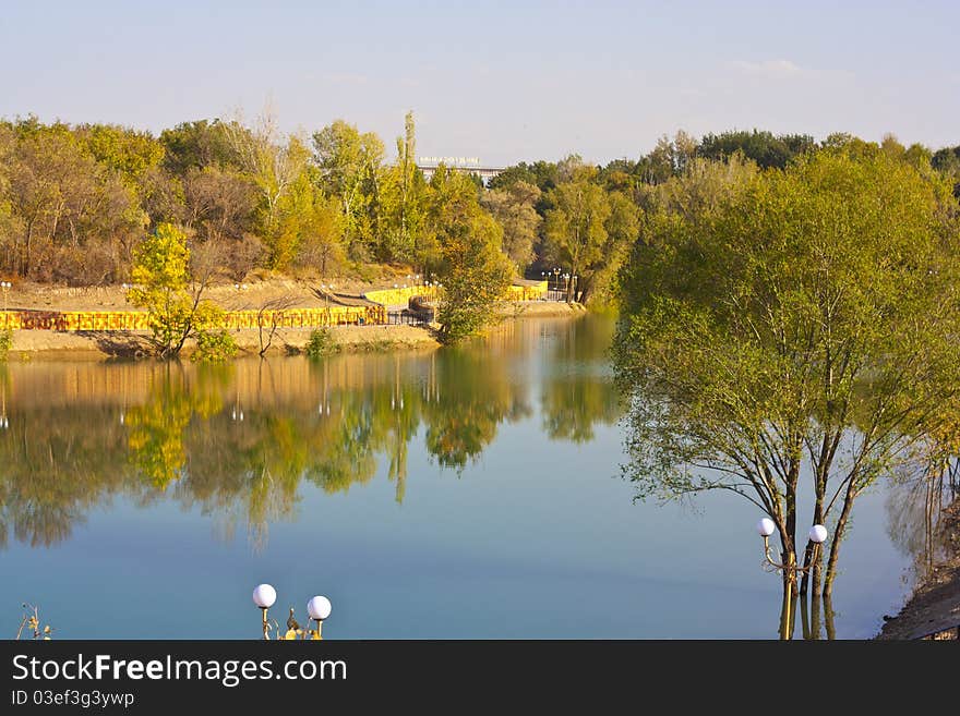 Picturesque autumn landscape of river and bright trees and bushes