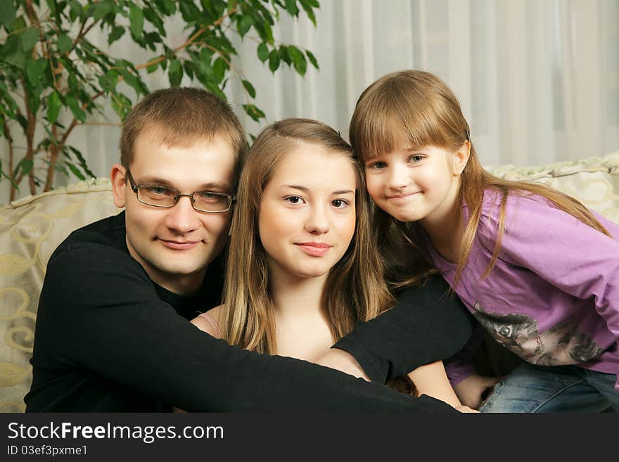 Father with his daughters sitting on sofa together. Father with his daughters sitting on sofa together