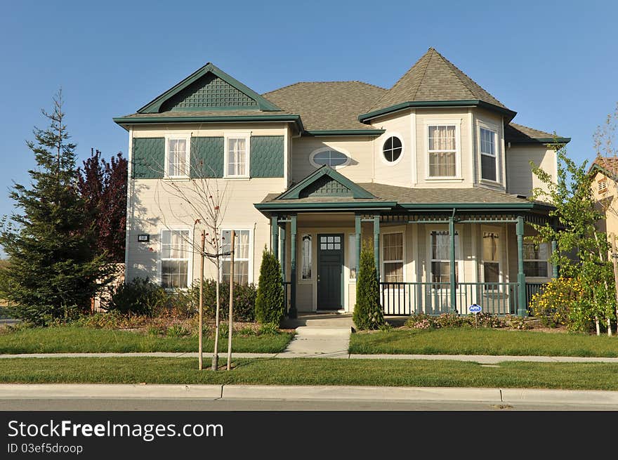 House surrounded by trees and grass with blue sky.