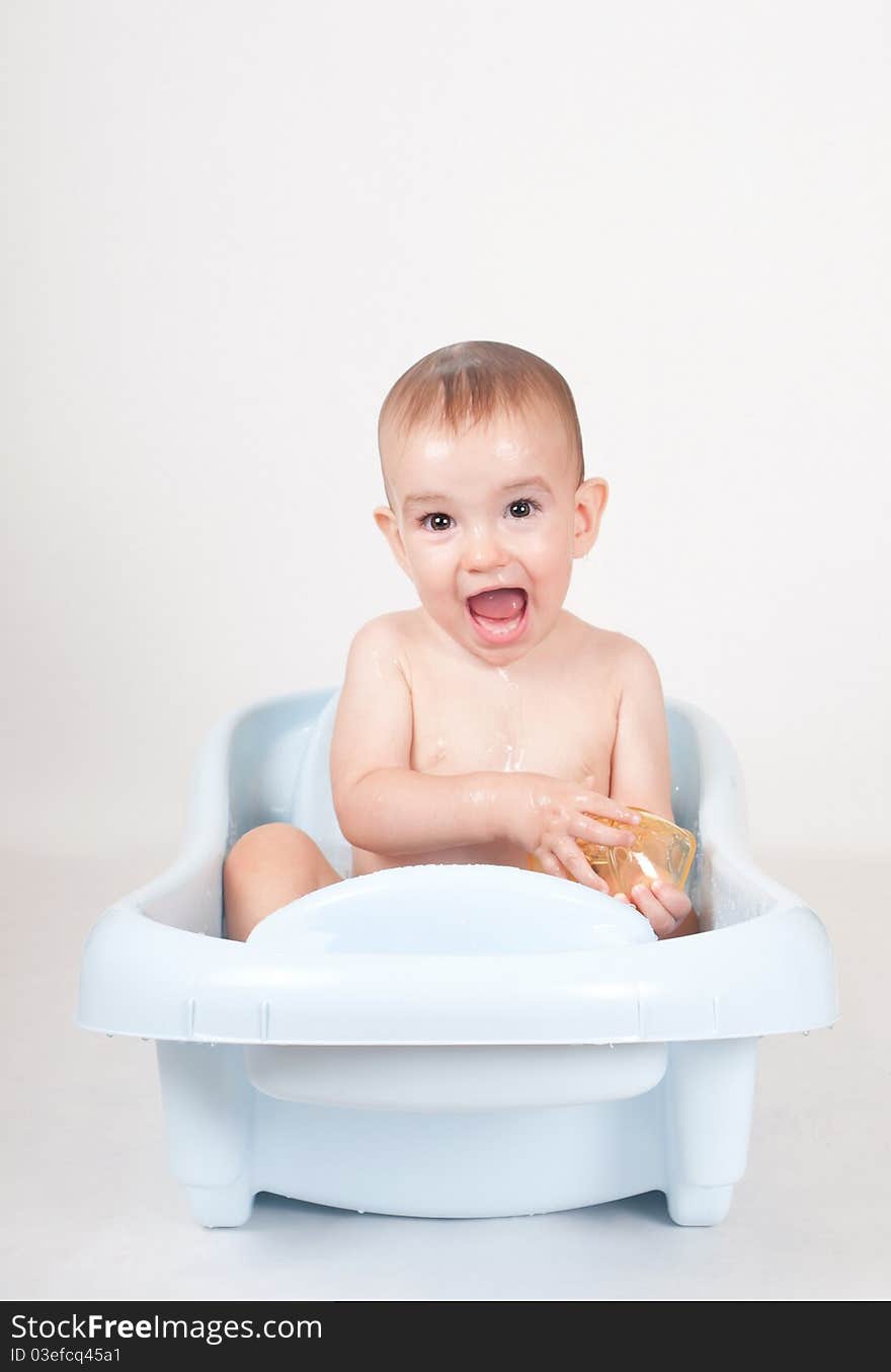 9 month old baby boy taking a bath exibiting happiness and fun. 9 month old baby boy taking a bath exibiting happiness and fun.