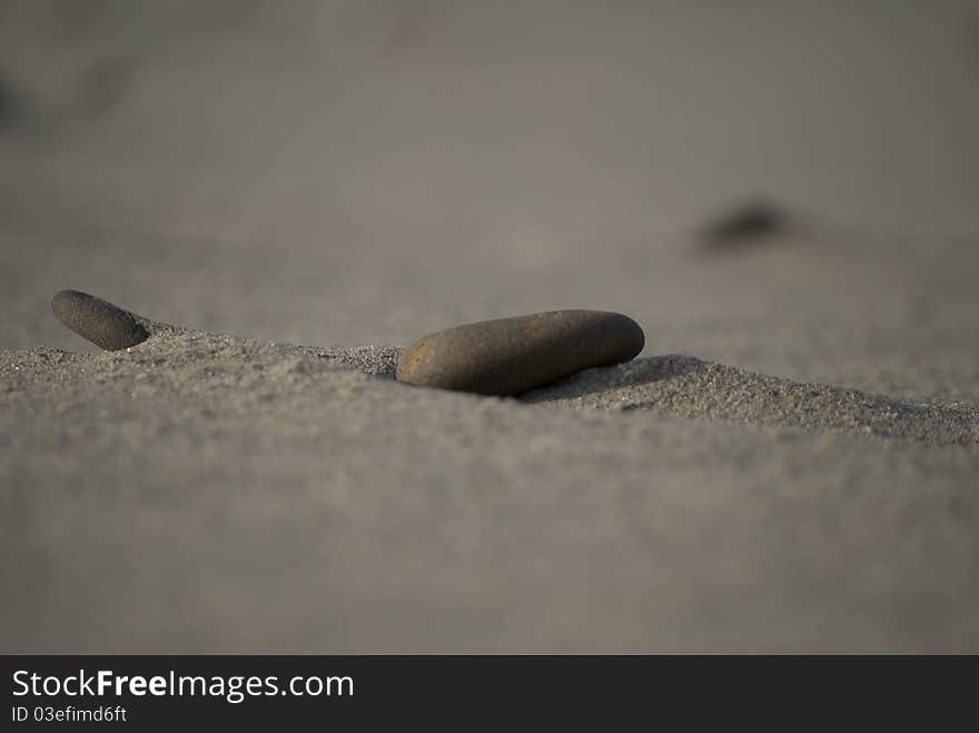 Small river rock in the sand, depth of field photo. Small river rock in the sand, depth of field photo