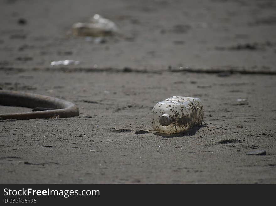 Empty bottle littered on the beach. Empty bottle littered on the beach