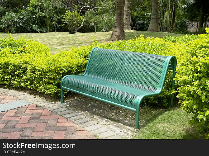 A modern metallic bench in peaceful garden of park. A modern metallic bench in peaceful garden of park