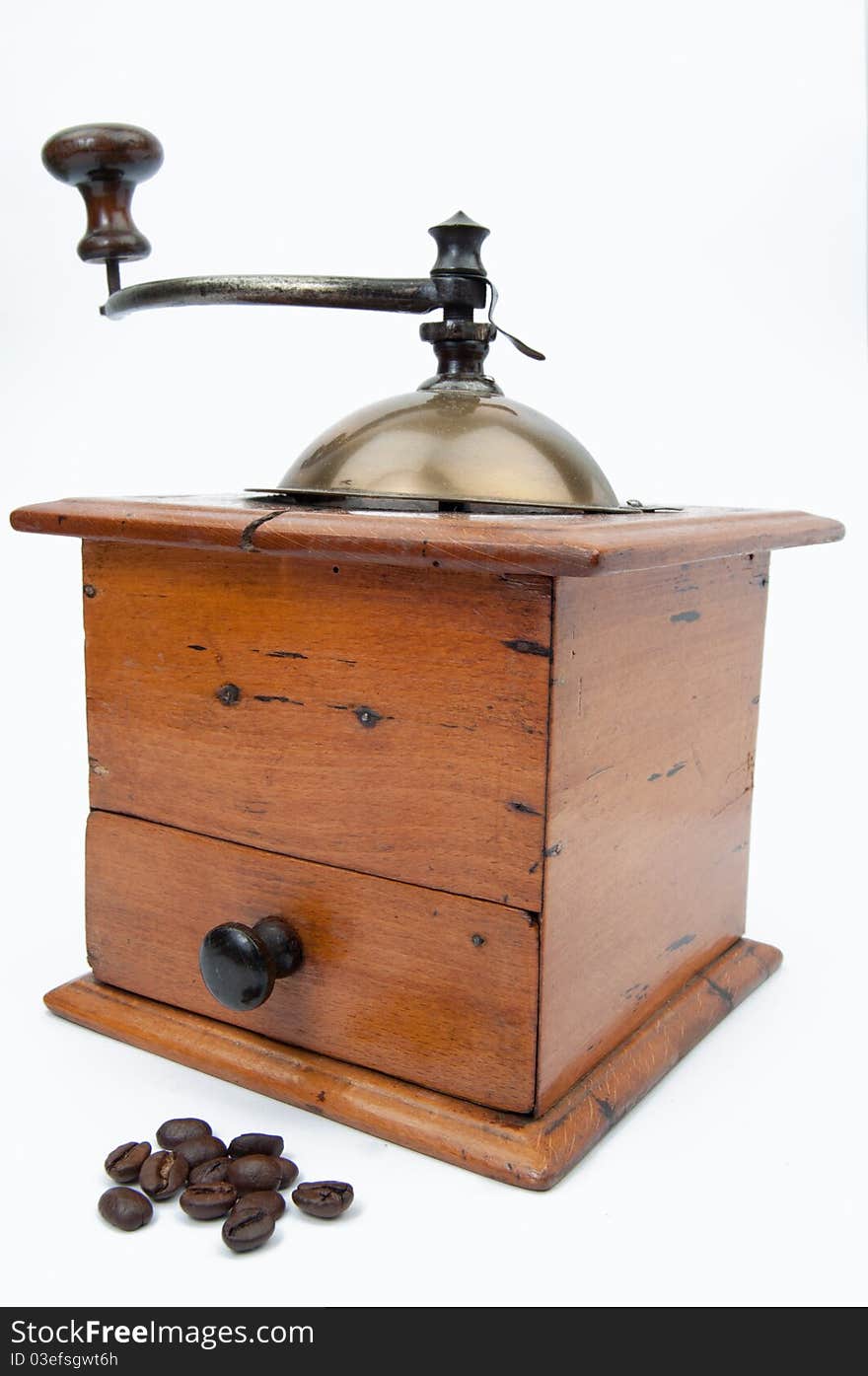 Old fashion coffee grinder against a white background with coffeebeans. Old fashion coffee grinder against a white background with coffeebeans