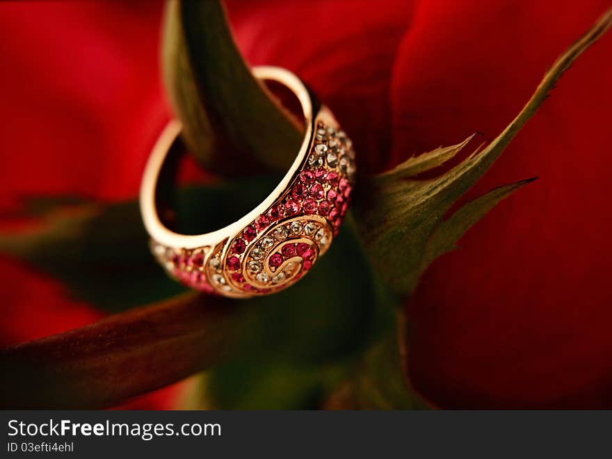 Ring with diamonds on the red rose caulis