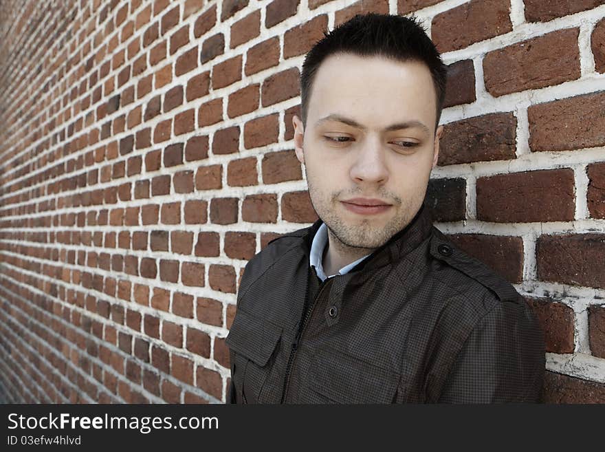 Young man in fron of the brick wall