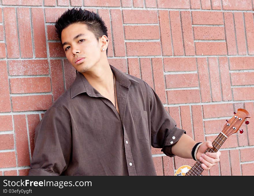 A photograph of a handsome young man with his Ukelele. A photograph of a handsome young man with his Ukelele