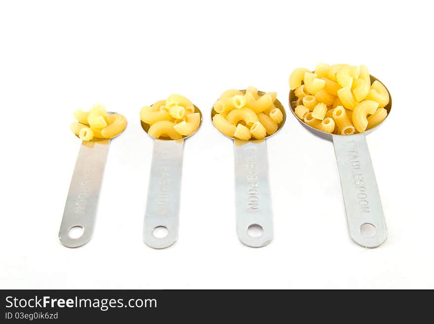 Macaroni measure spoon on white background