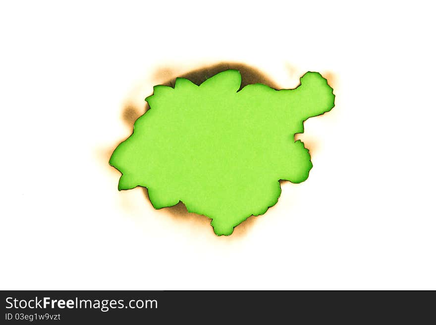 Burnt hole in a paper over green paper background