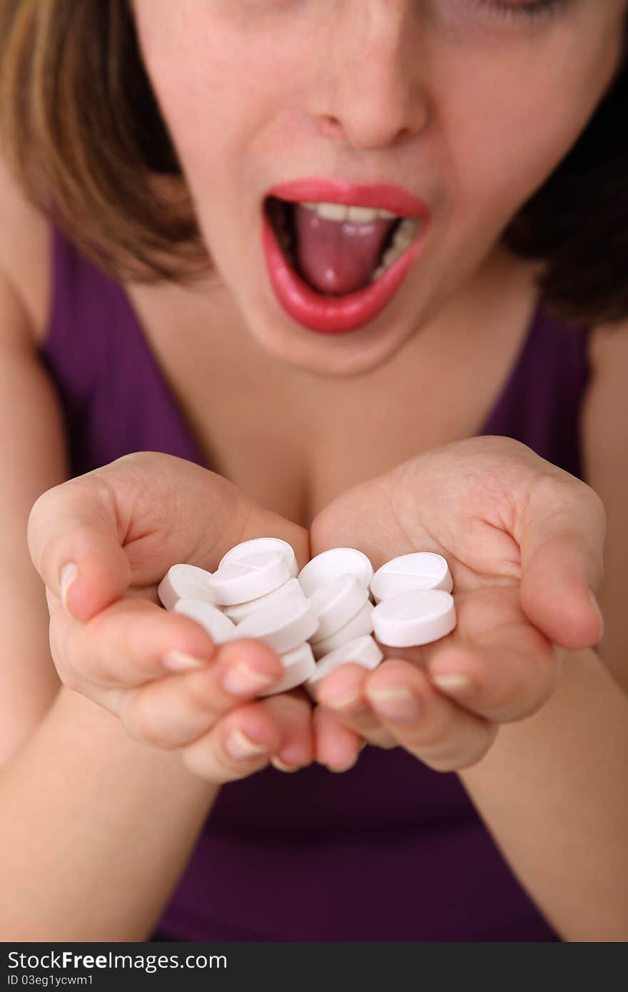 Close-up of a young woman holding many white pills in her hands. Shallow depth of field, focus on pills. Close-up of a young woman holding many white pills in her hands. Shallow depth of field, focus on pills.