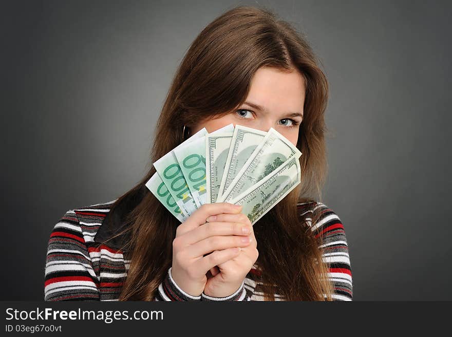 Pretty woman smiling while holding fan made of money. Pretty woman smiling while holding fan made of money