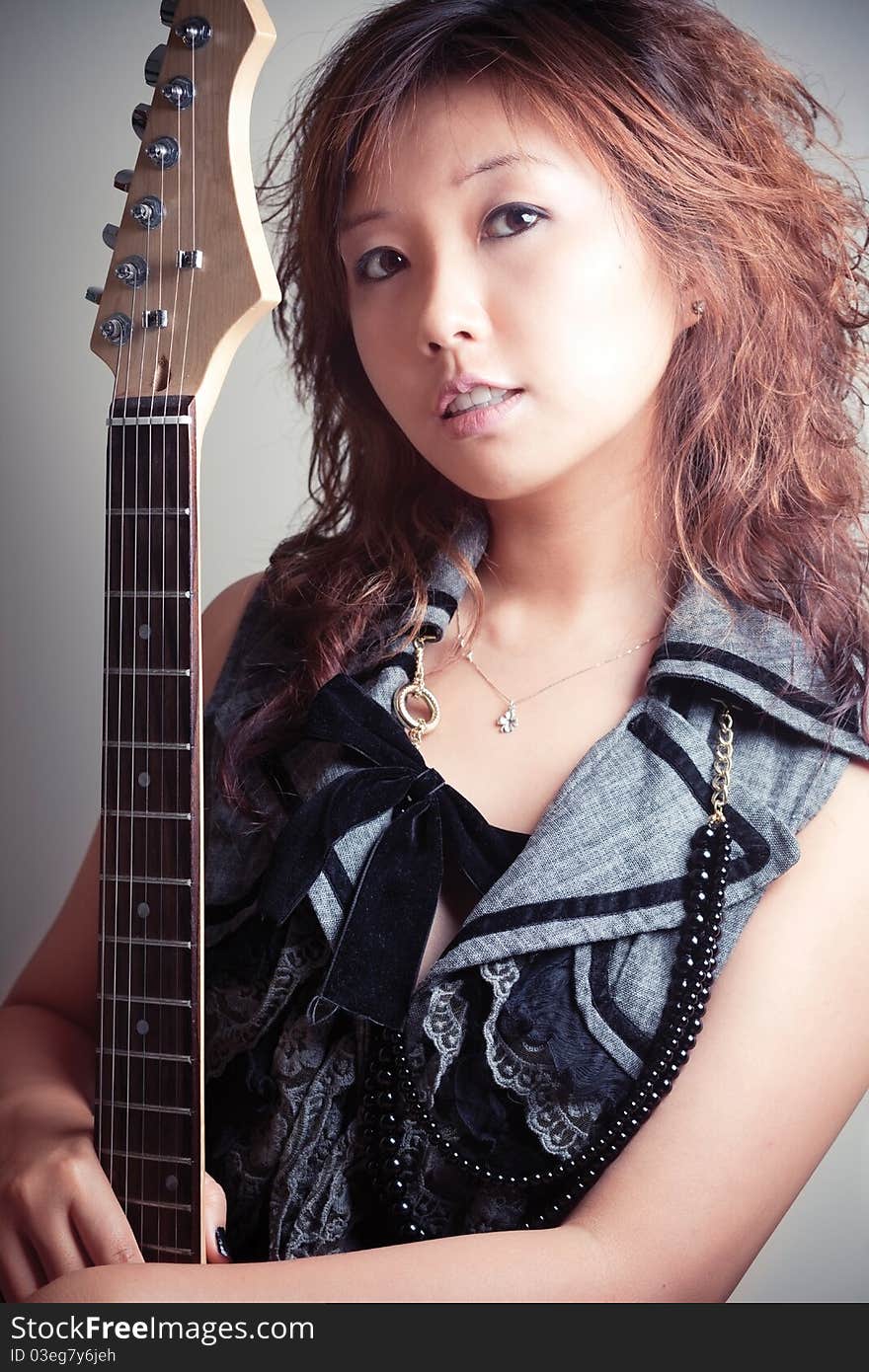 Young asian woman with a red guitar. Young asian woman with a red guitar.