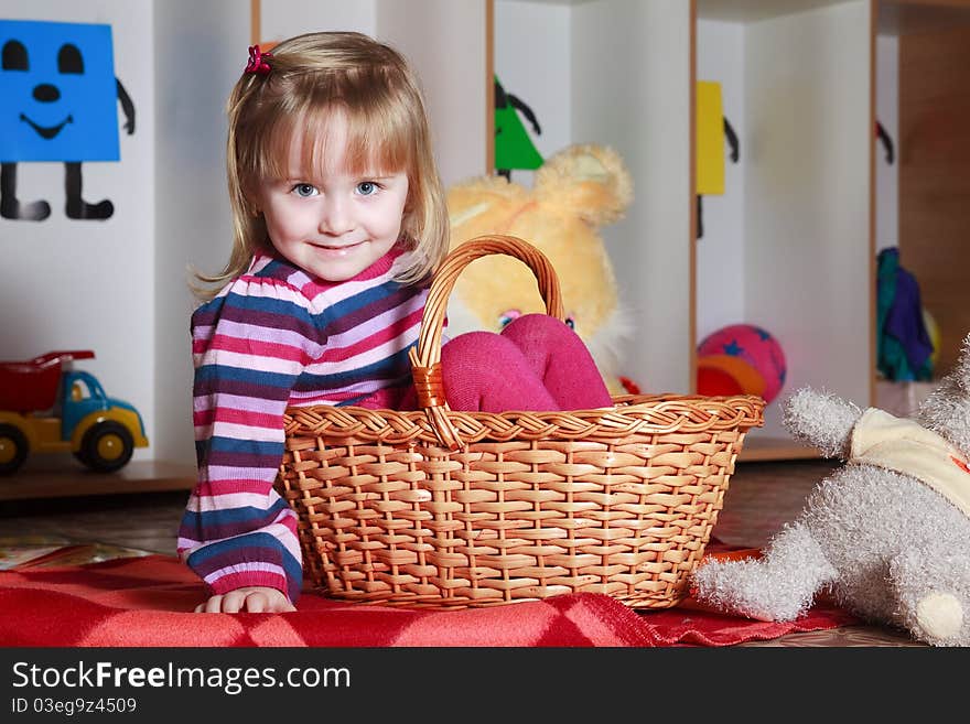 Little girl with basket playing with her toys