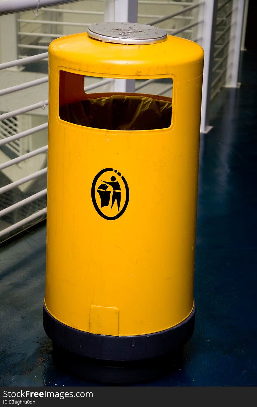 Yellow garbage bin in public. Yellow garbage bin in public