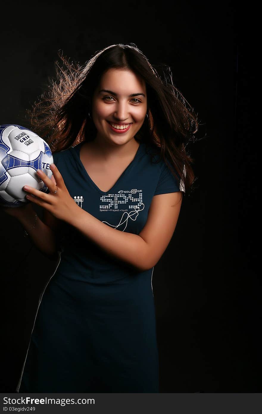 Girl with a football on the black background. Girl with a football on the black background