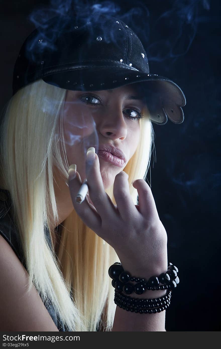 Young pretty girl is smoking cigarette