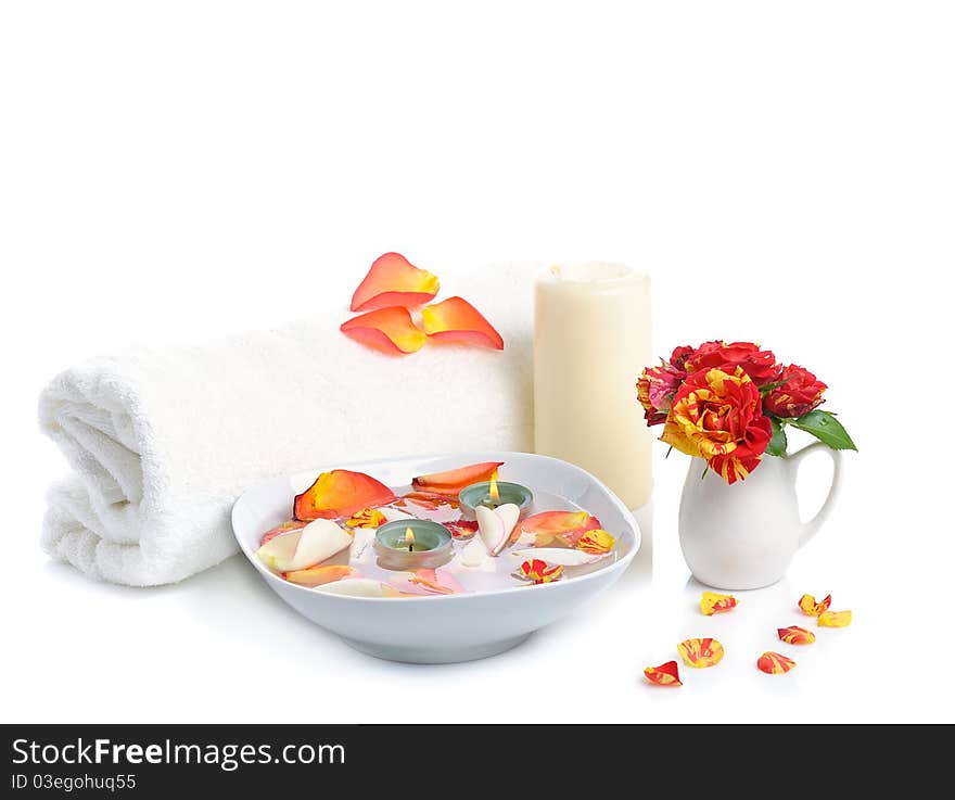 Bowl with rose petals, rose candle and towels on white background. Bowl with rose petals, rose candle and towels on white background