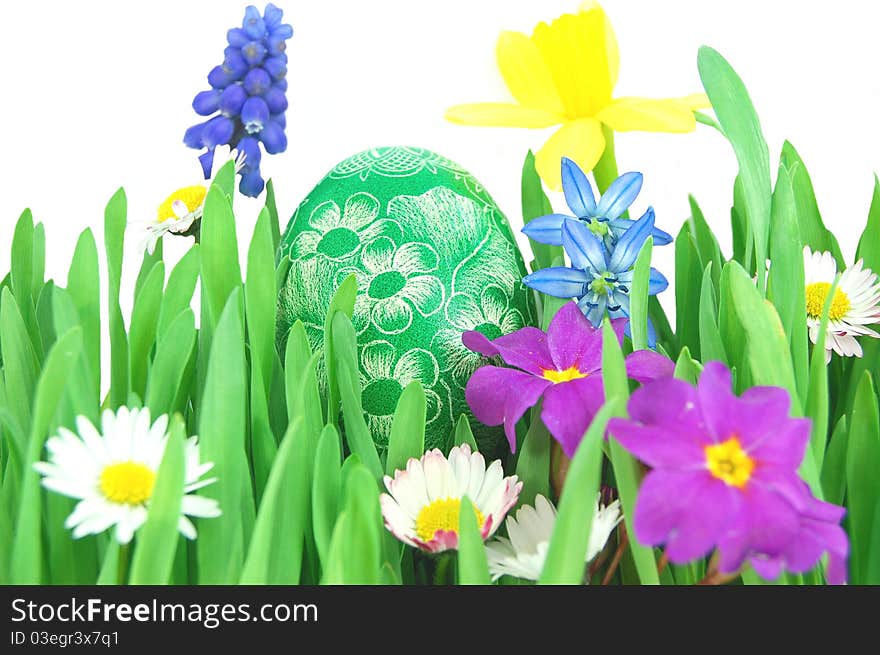 Traditional scratched hand-made Easter egg on a spring meadow